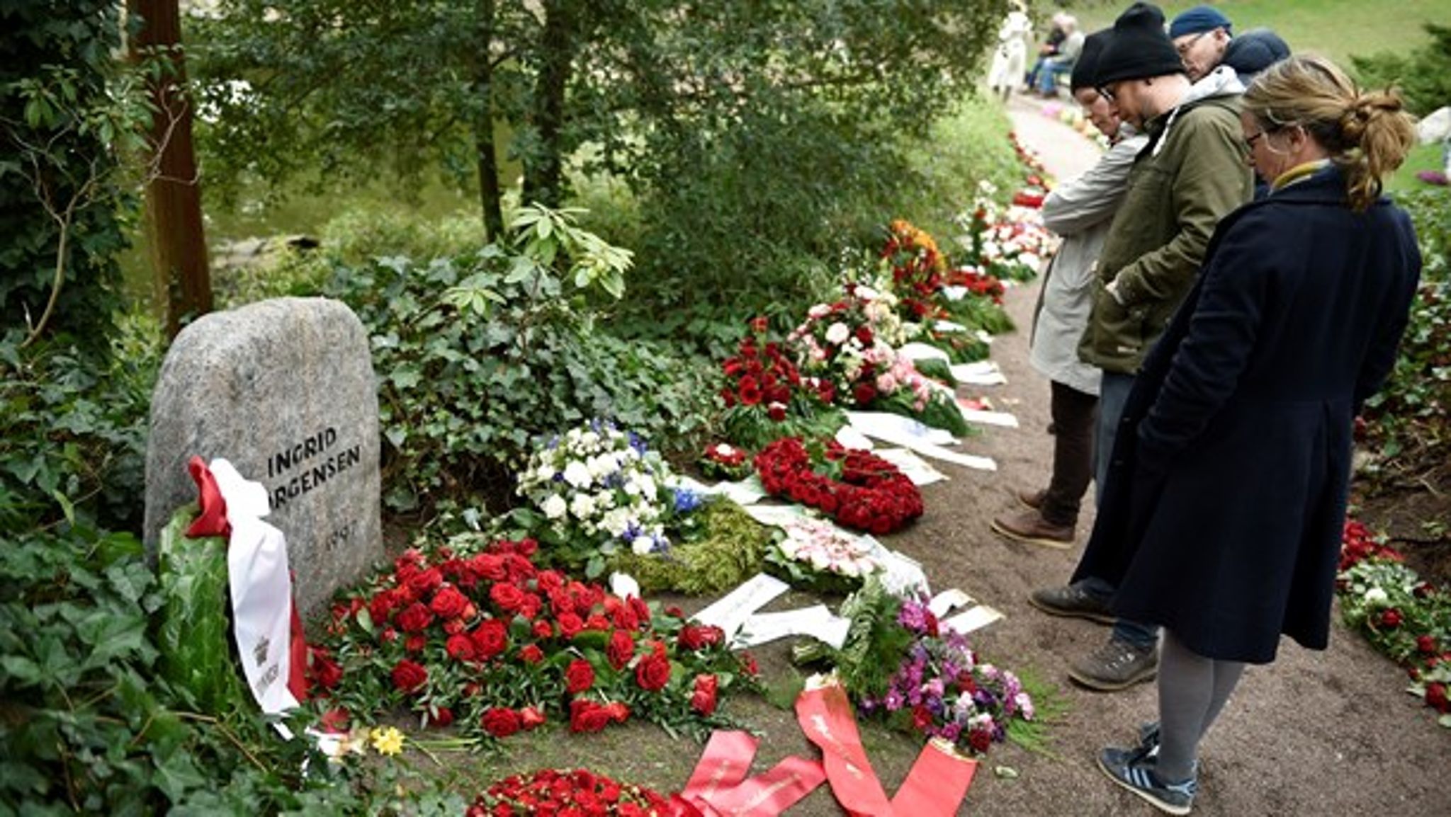 Besøgende kigger på blomster og bårebuketter på Vestre Kirkegård dagen efter bisættelsen af tidligere statsminister Anker Jørgensen i april 2016.