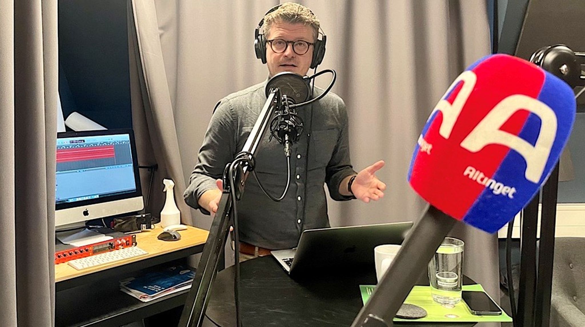 #dkpol hedder fredags-podcasten fra studiet på fjerde sal i Altingets hovedkvarter i Ny Kongensgade ved Christiansborg i København. Politisk redaktør og vært Esben Schjørring varmer op under sin makker, chefredaktør Jakob Nielsen, der har taget dette snapshot, før det går løs. Programmet har hver uge op mod 15.000 trofaste lyttere.