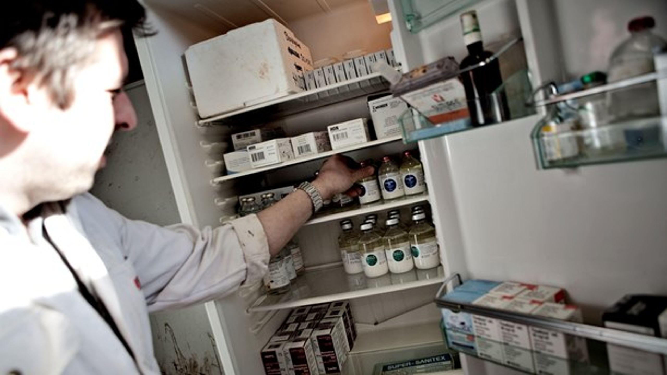 En dyrlæge tjekker medicinbeholdningen hos en svineavler.