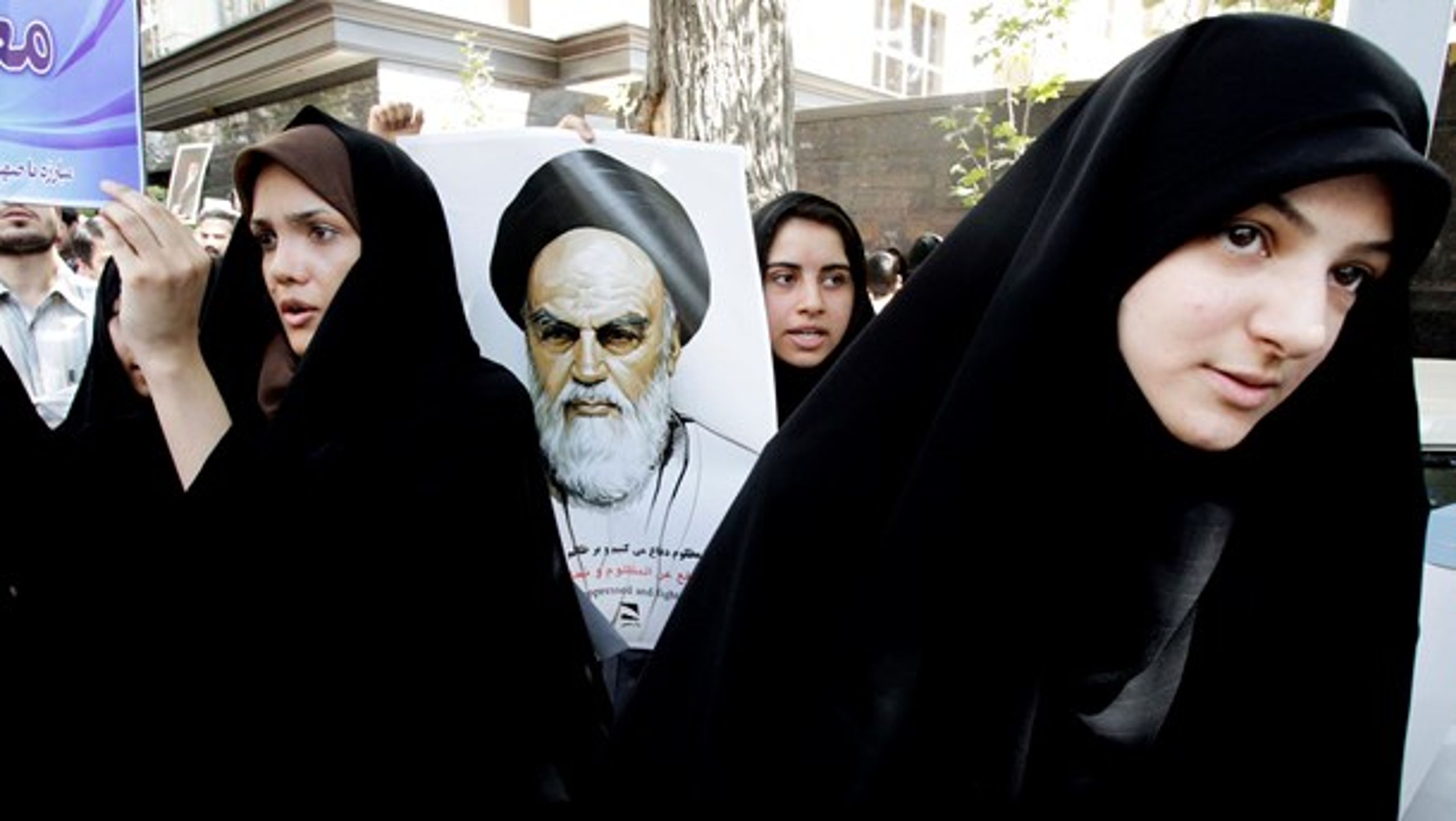 Iranske demonstranter med en plakat af den iranske revolutions leder, Ayatollah Khomeini, protesterer ved den schweiziske ambassade mod en film, der latterliggør profeten Muhammed (sept. 2012).<br>