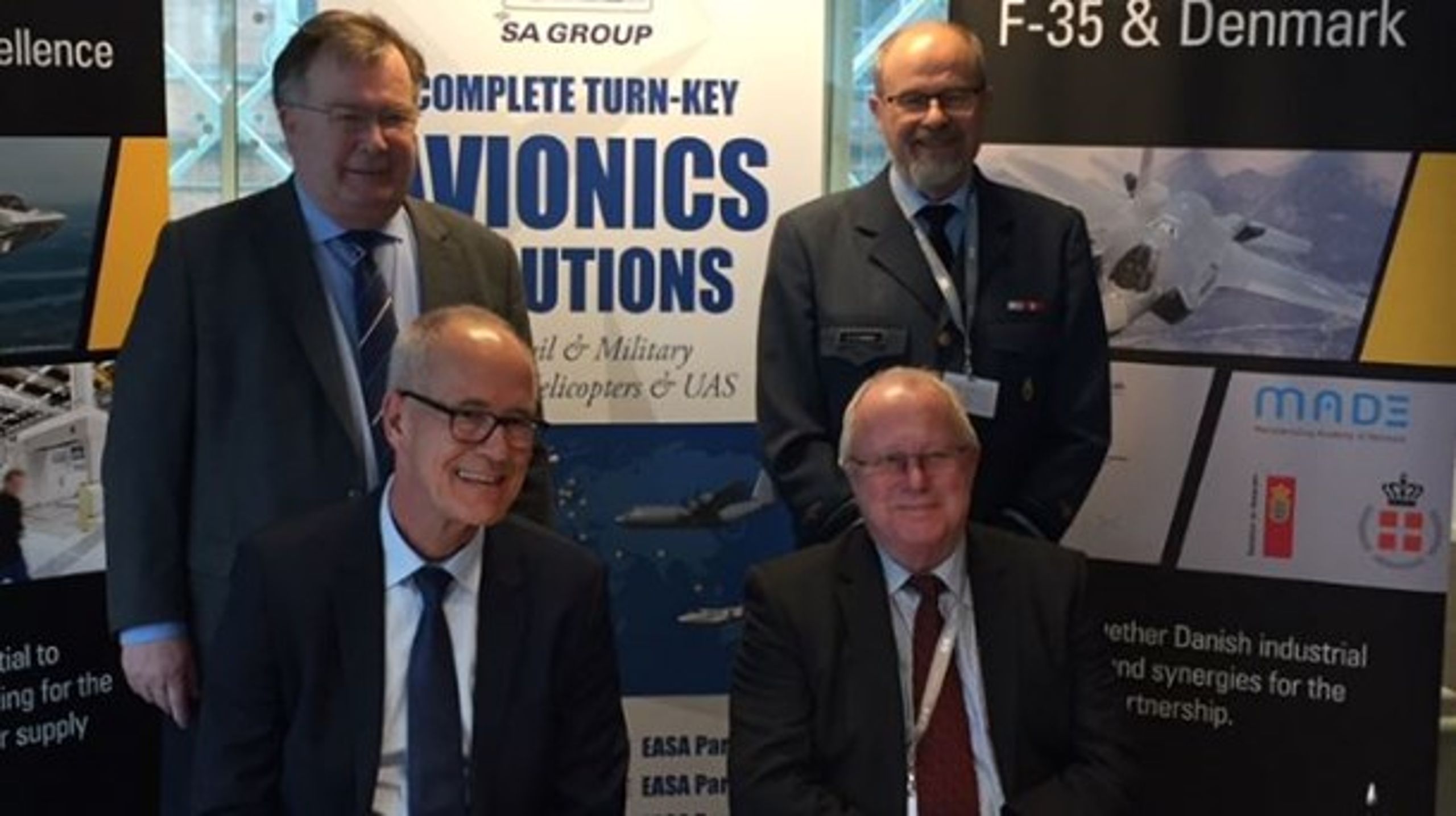 Direktør Jens Maaløe fra Terma (tv.) og vicedirektør Søren Pedersen fra Scandinavian Avionics (th.) med forsvarsminister Claus Hjort Frederiksen (tv.) og generalmajor Henrik Lundstein (th.) i baggrunden.