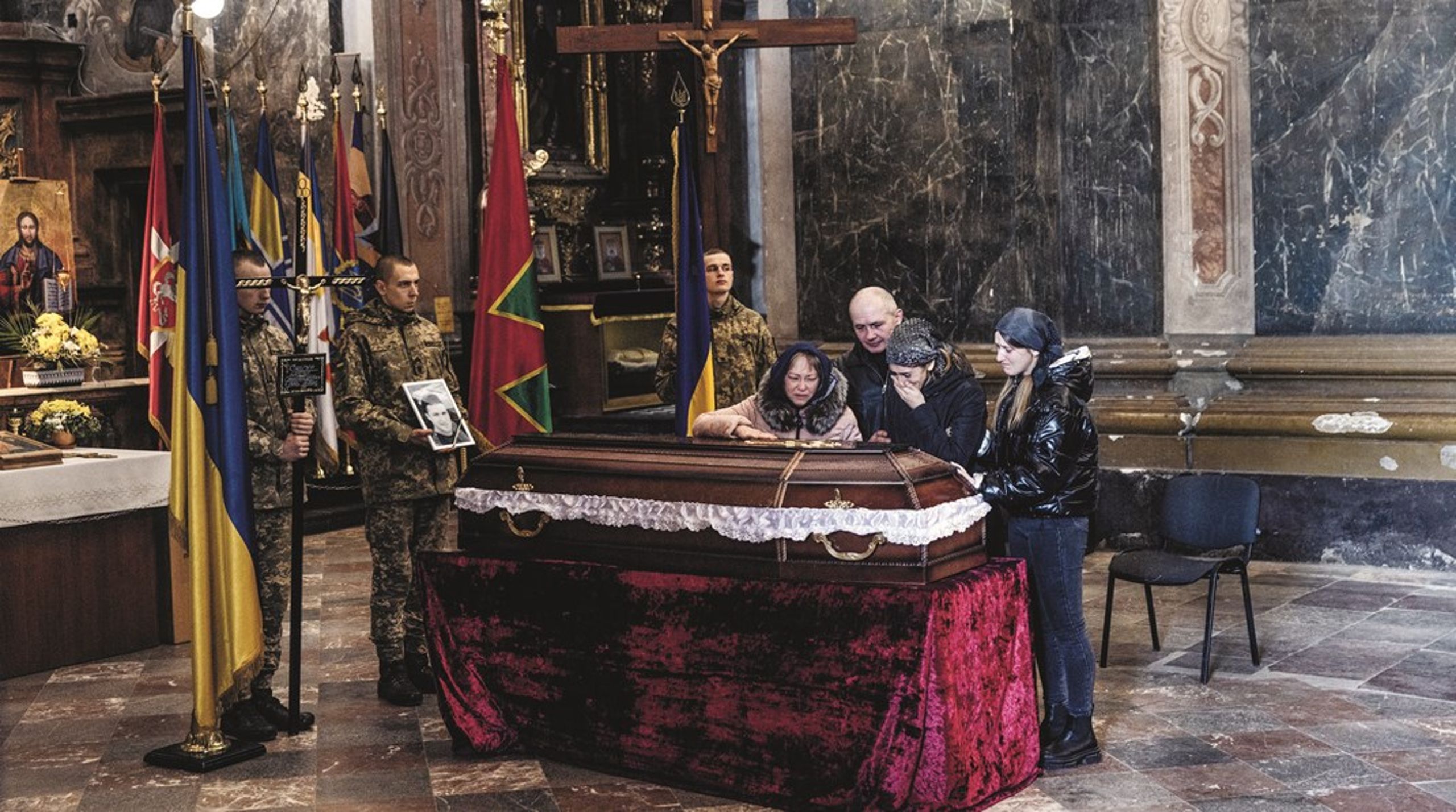 I Peter og Paulus Garnisonskirken til ukrainske Denys Svigurs begravelse høres luftalarmerne udenfor, men de pårørende trodser advarslerne cermonien igennem.