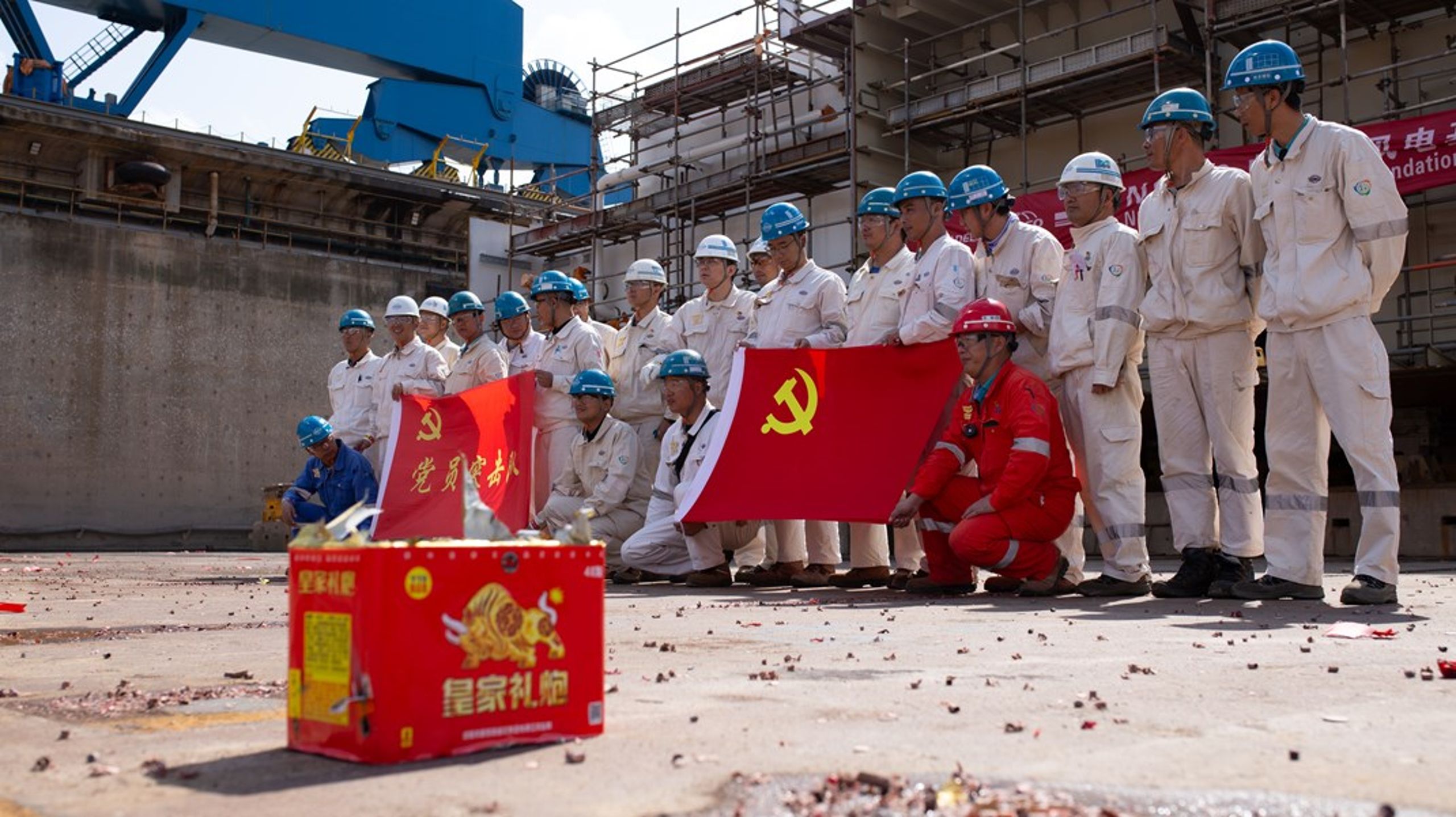 Værftsarbejdere flager med hammer og segl foran kølen til Cadelers kommende vindmølleskib.&nbsp;