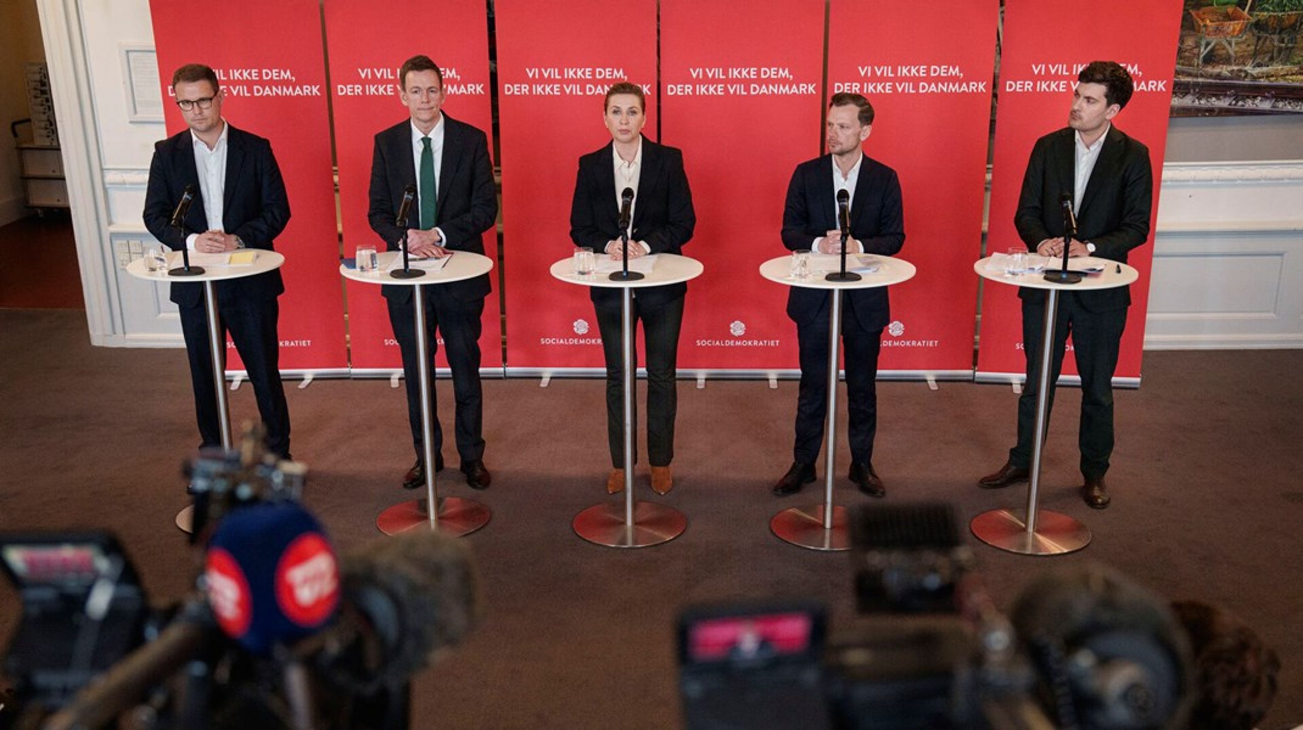 Flere prominente S-profiler flankerede Mette Frederiksen på tirsdagens pressemøde. "Det er et klart signal om, hvor meget de prioriterer det," siger kommentator.