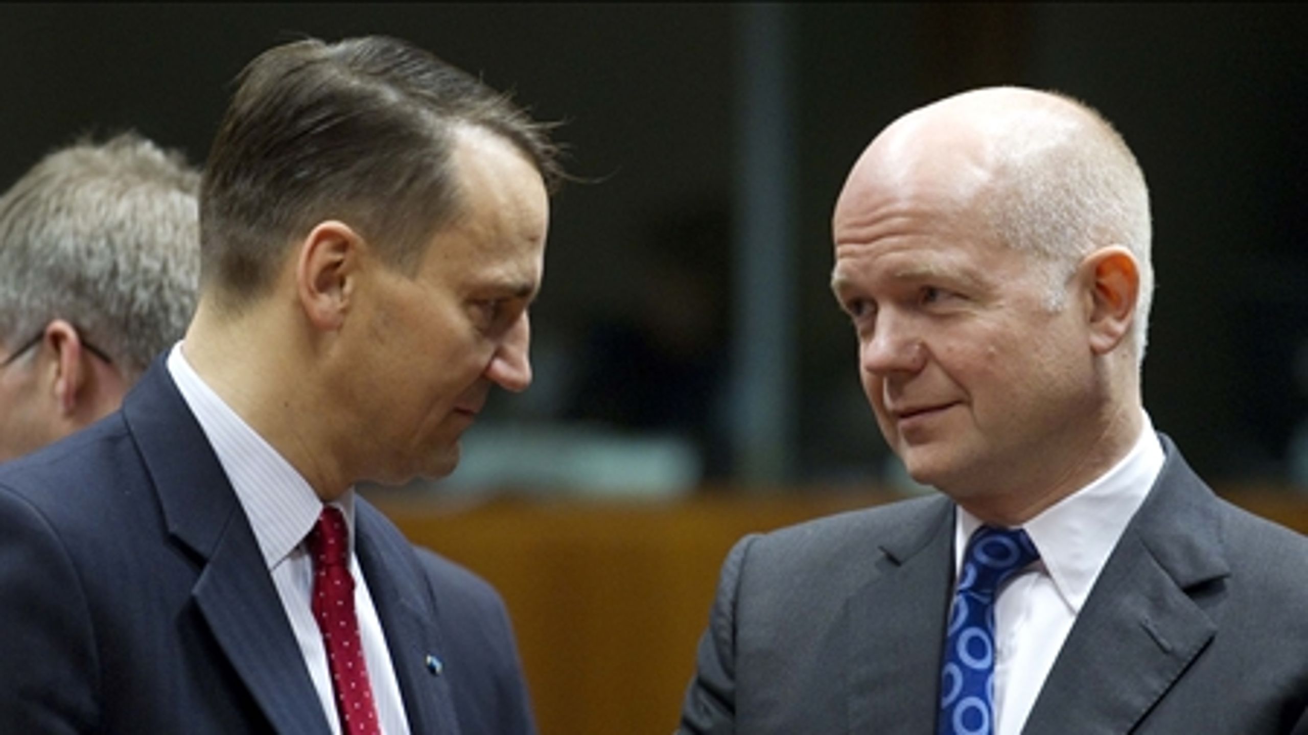 Den polske udenrigsminister Radoslaw Sikorski (t.v.) i samtale med sin britiske kollega William Hague (t.h.). De to står på hver sin side af velfærdsturismedebatten.