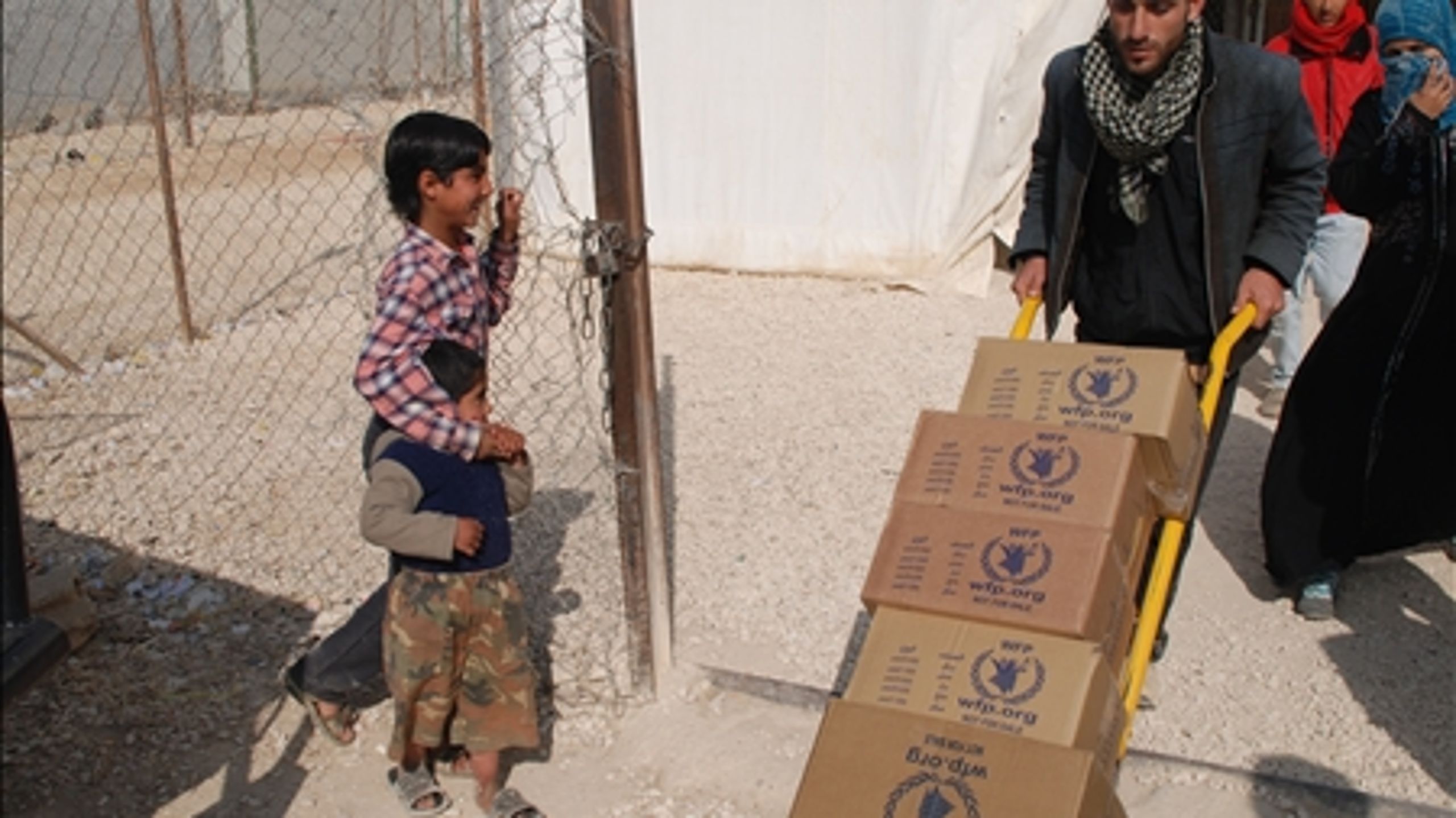 To drenge holder øje med madvarer, der bliver flyttet i Za'atari-lejren i Jordan, der huser over 100.000 syriske flygtninge. Januar 2014. 