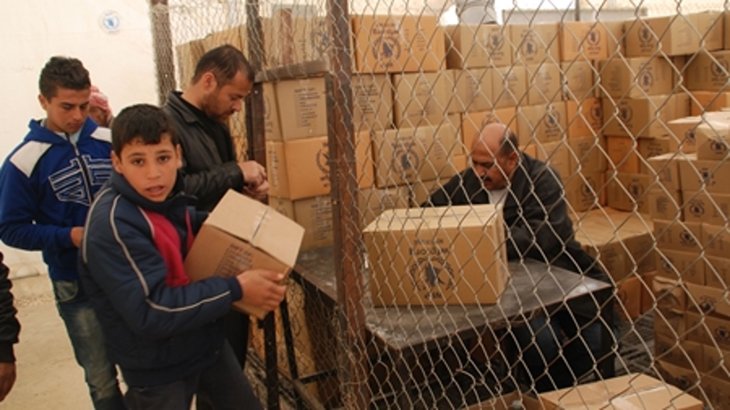 Dreng modtager nødhjælpspakke med madvarer i Za'atari-lejren i Jordan, der huser over 100.000 syriske flygtninge. Januar 2014.