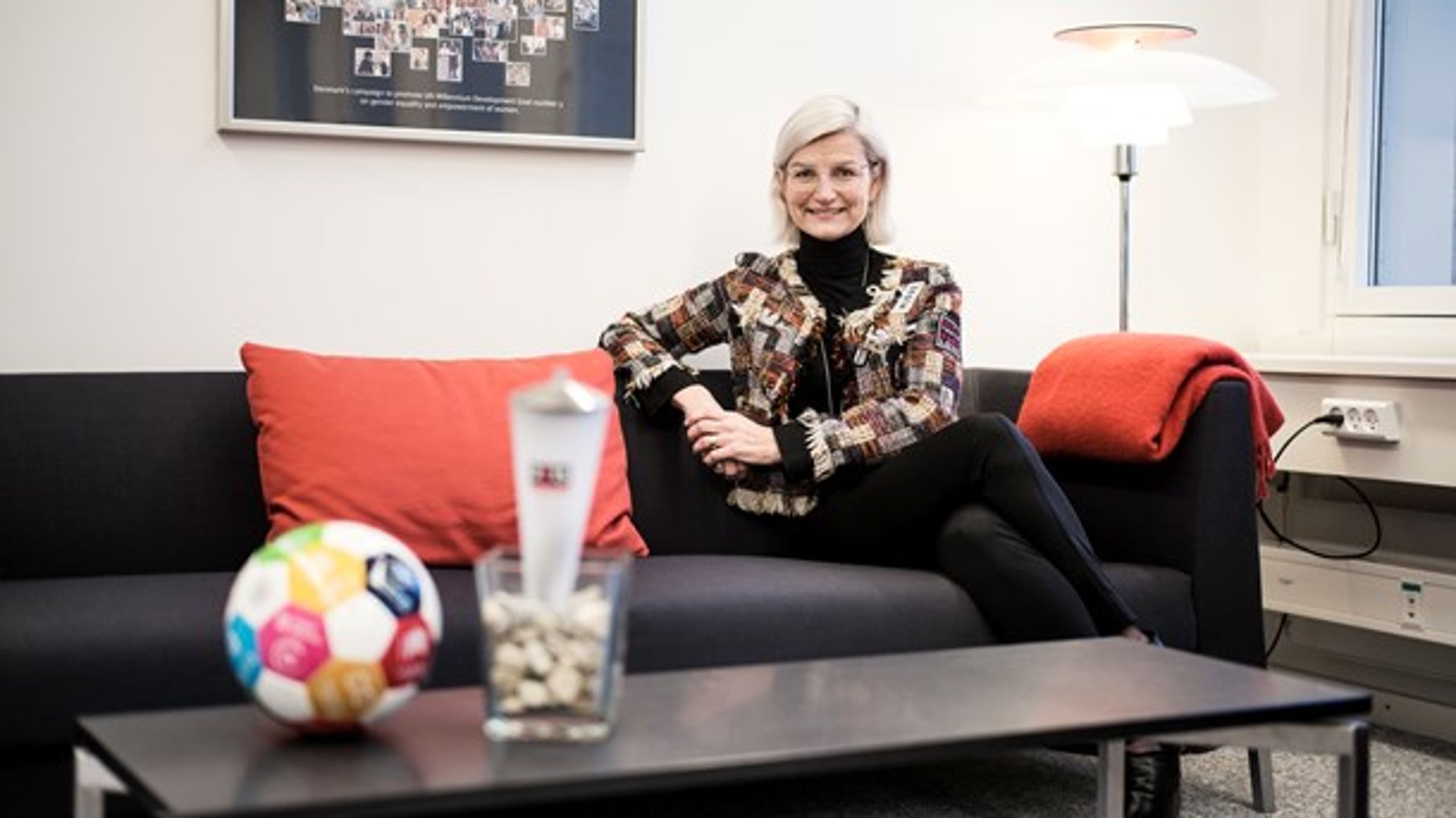 Udviklingsminister Ulla Tørnæs (V) på sit ministerkontor på toppen af Udenrigsministeriet. Foran hende er en fakkel, der repræsenterer hendes tidligere periode som minister, og en fodbold, der&nbsp;repræsenterer de nye tider i udviklingsarbejdet.