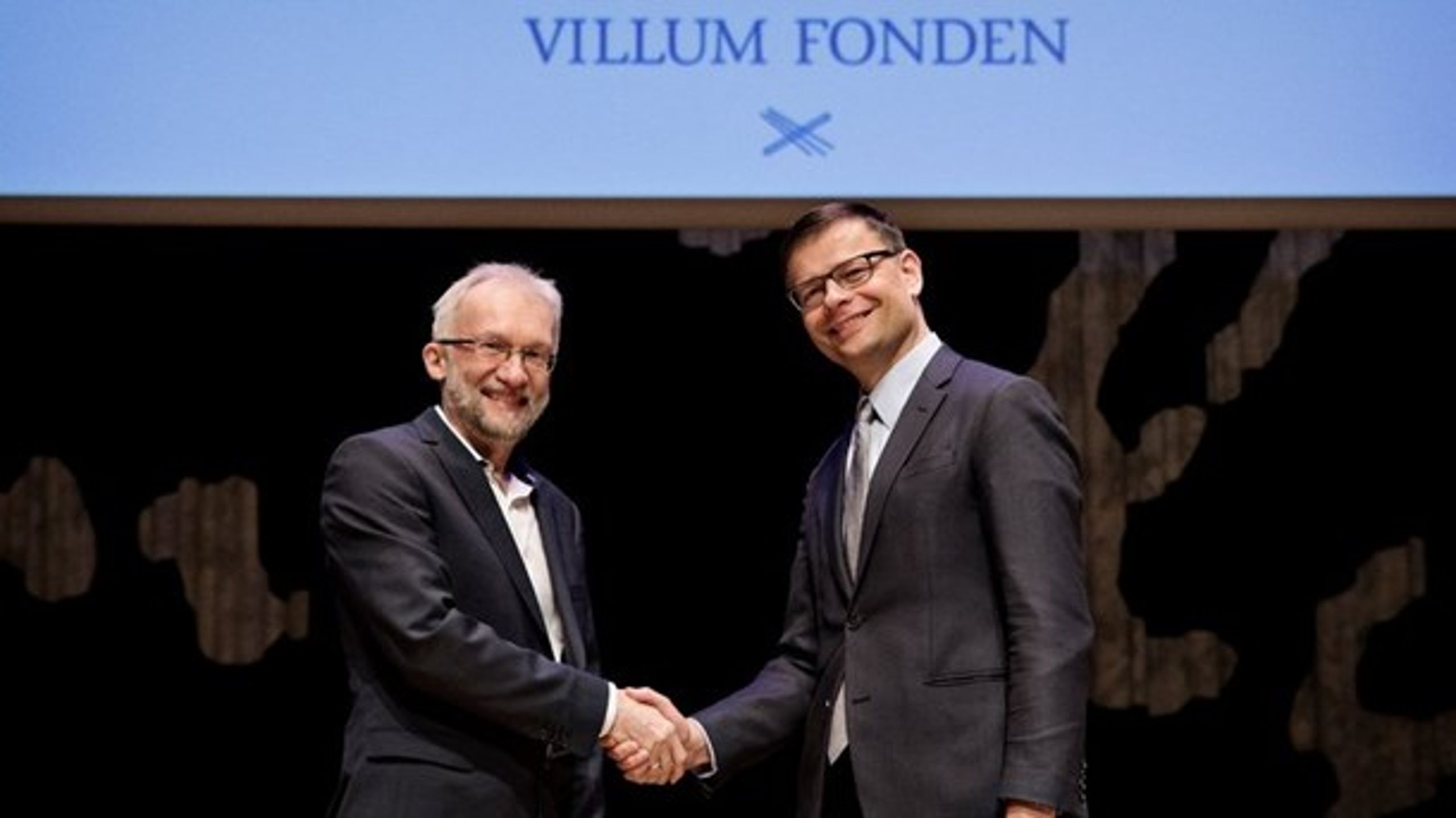 Bestyrelsesformand for Villum Fonden Jens Kann-Rasmussen og prismodtager professor Ivan Damgård giver hinanden hånden, efter at Damgård har fået overrakt årslegatet.<br>