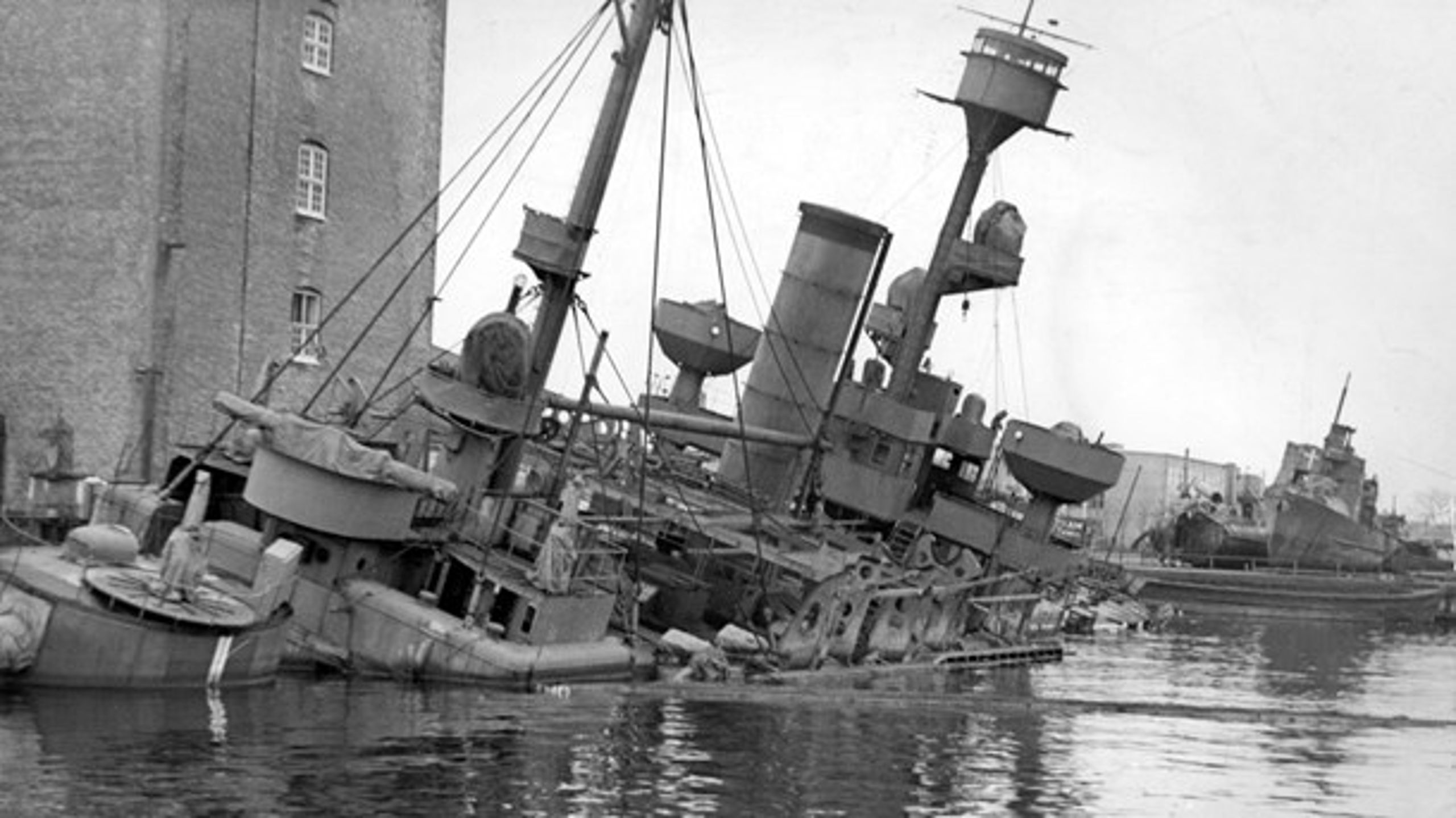 Da de tyske besættelsestropper ved firetiden om morgenen 29. august 1943 rykkede ind på Holmen, blev der givet signal til at iværksætte den planlagte sænkning af flådens skibe. Her kystforsvarsskibet Peder Skram under Mastekranen.