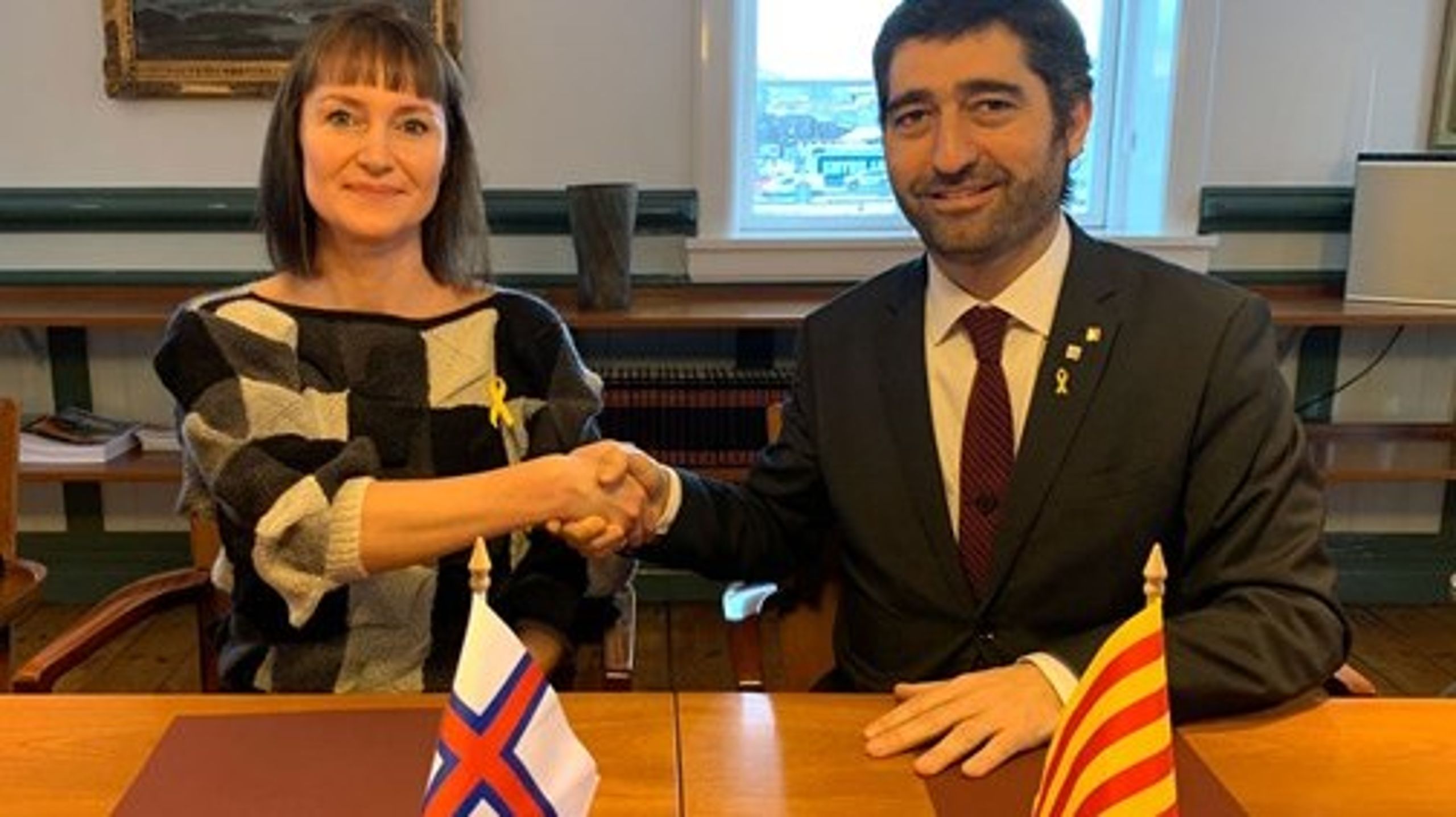Færøernes finansminister, Kristina Háfoss, og Cataloniens minister for digitalisering og offentlig administration, Jordi Puigneró, giver hånd på samarbejdsaftalen mellem de to territorier.&nbsp;