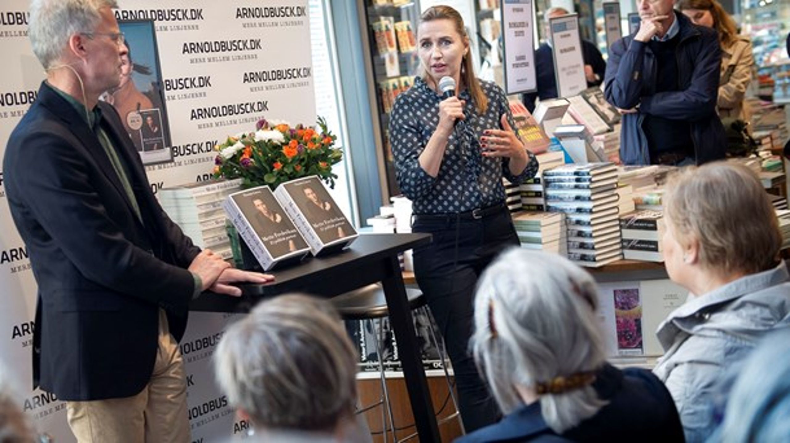Mette Frederiksen fortalte om den nye portrætbog i en boghandel i København onsdag formiddag sammen med forfatter Thomas Larsen (tv.). I bogen udstikker hun blandt andet en garanti om kun at lempe visse dele af udlændingepolitikken, hvis DF og V er med.