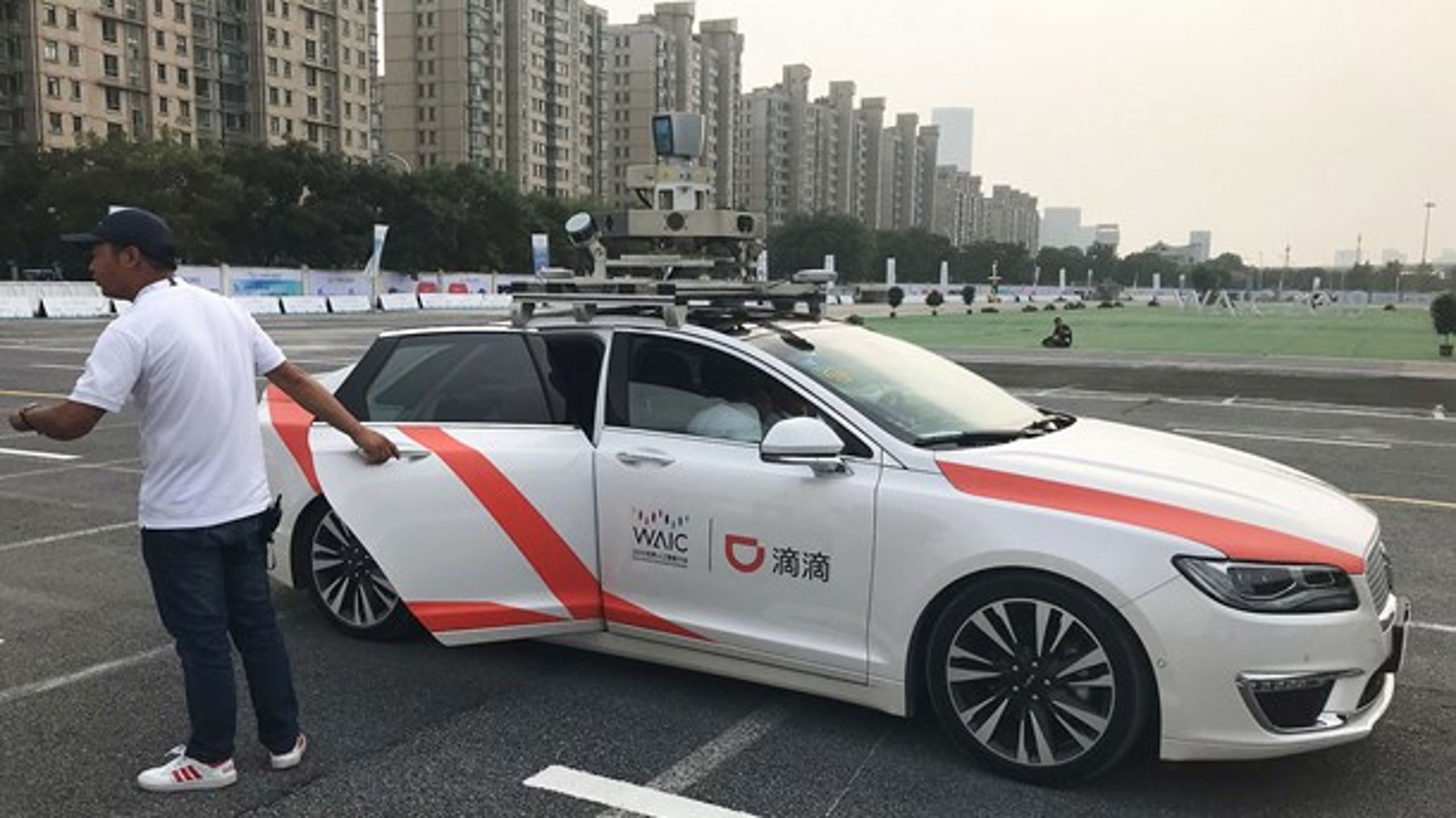 En mand holder døren til en selvkørende bil under World Artificial Intelligence Conference (WAIC) i Shanghai, 30. august 2019.