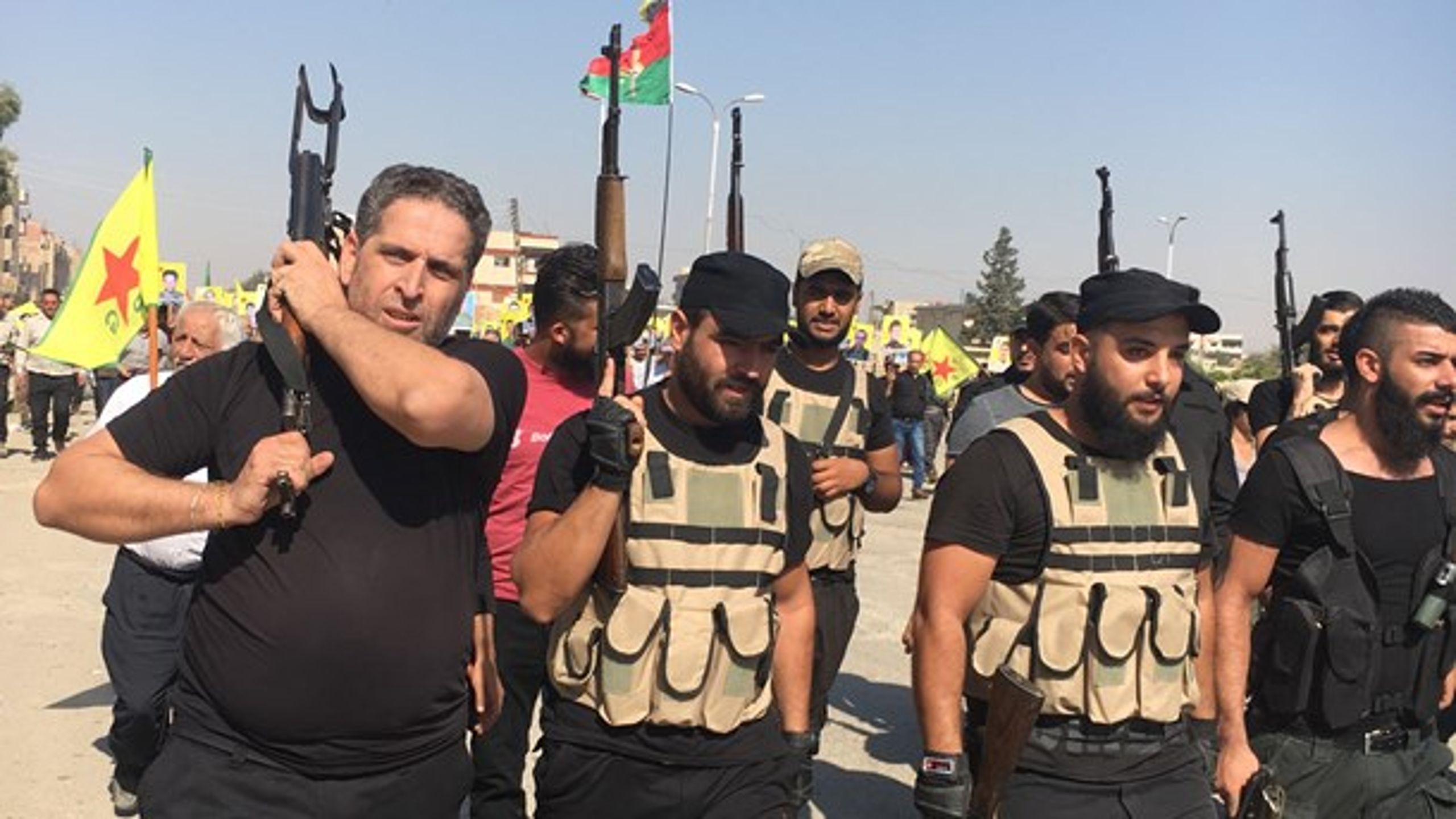 Ifølge øjenvidne&nbsp;Jenan Jamil Bozo gik næsten 20.000 mennesker på gaden og demonstrerede torsdag formiddag foran FN-kontoret i den syriske by Qamishli. På billedet ses tre kurdiske tropper med ladte geværer.<br>