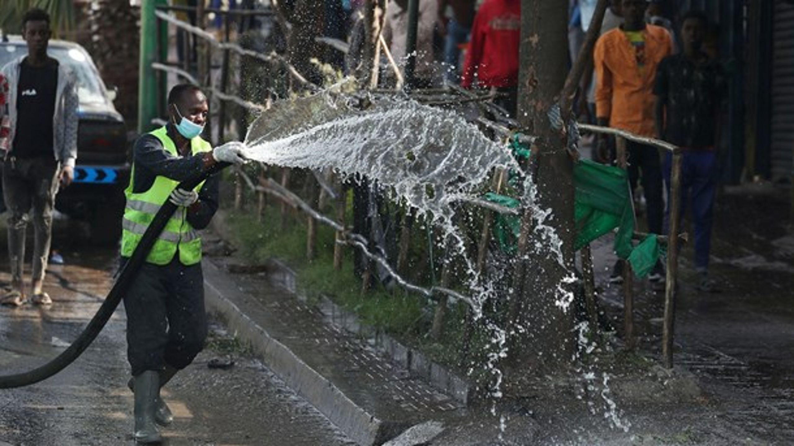 En ethiopisk sundhedsarbejder sprøjter desinficerende væske på gaden for at forhindre udbredelsen af coronavirussen.