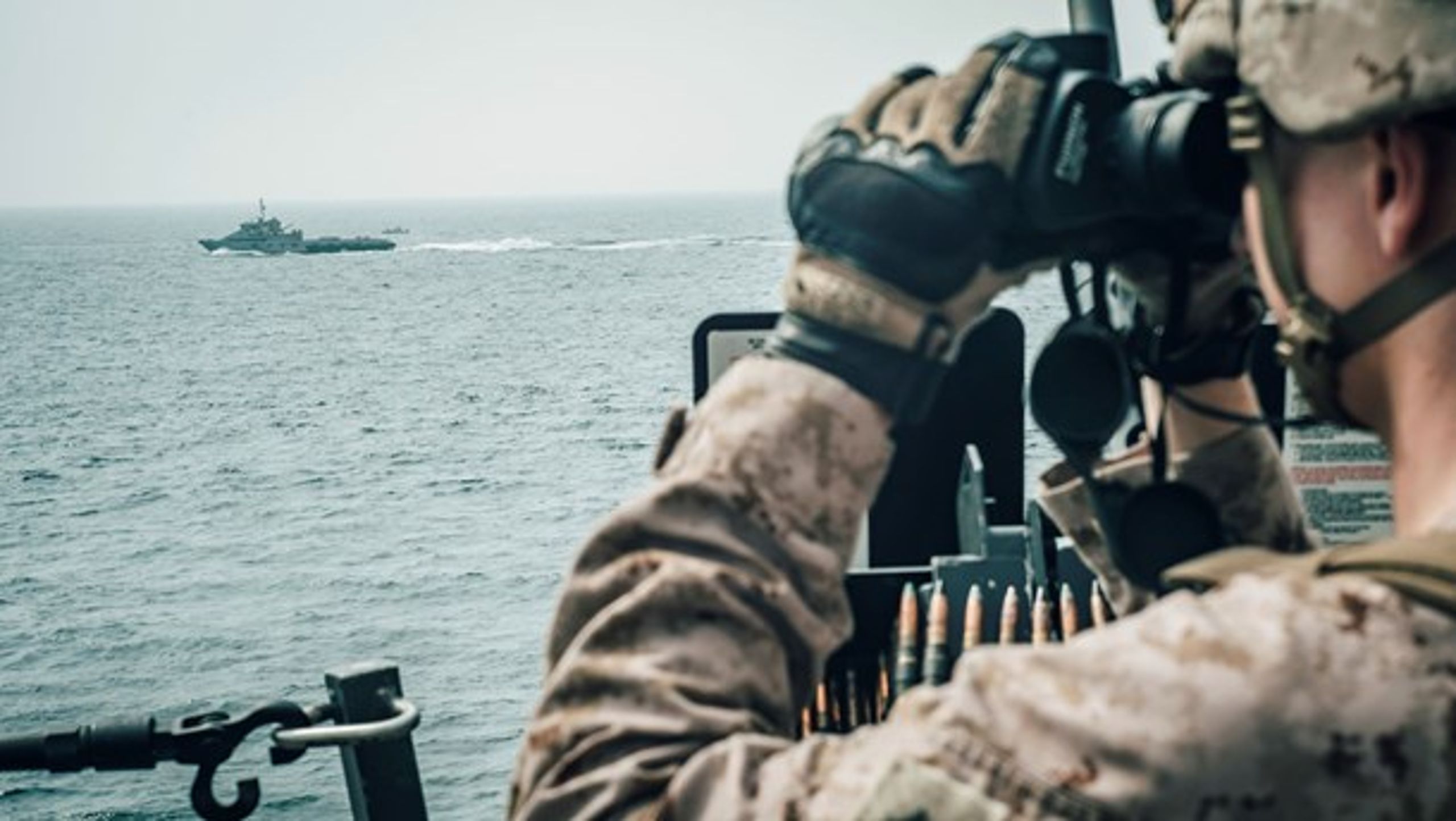 En amerikansk marinesoldat observerer et iransk patruljeskib i Hormuzstrædet i juli 2019.