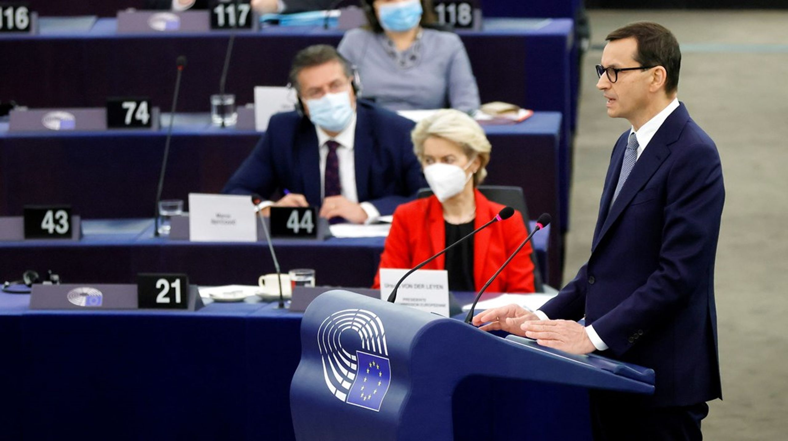 Polens regeringsleder, Mateusz Morawiecki, på talerstolen&nbsp;og kommissionsformand Ursula von der Leyen i baggrunden.&nbsp;