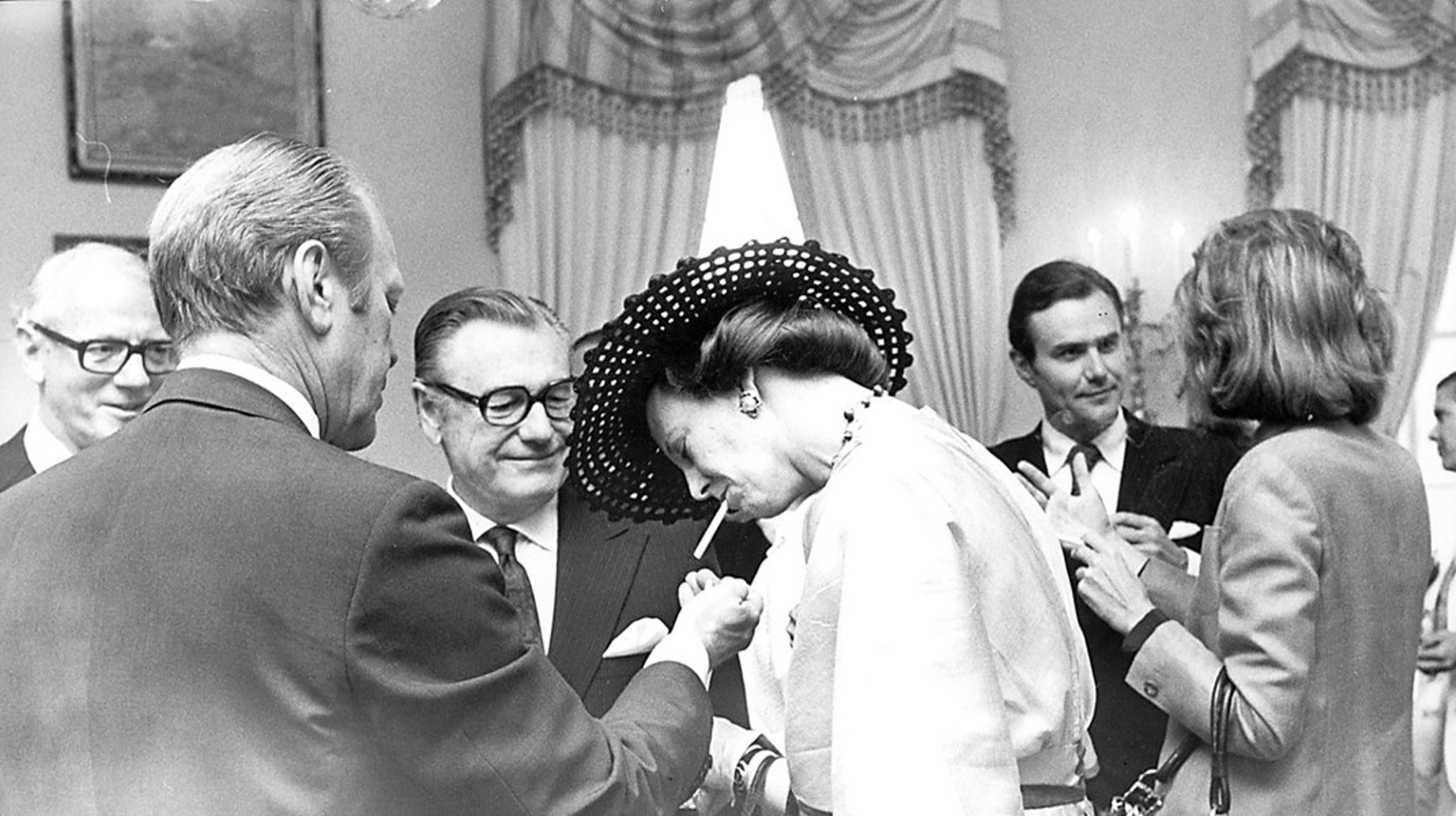 Dronningen har været vidt omkring. Her tænder den tidligere
amerikanske præsident Gerald Ford hendes cigaret under et statsbesøg i USA. (Arkivfoto)