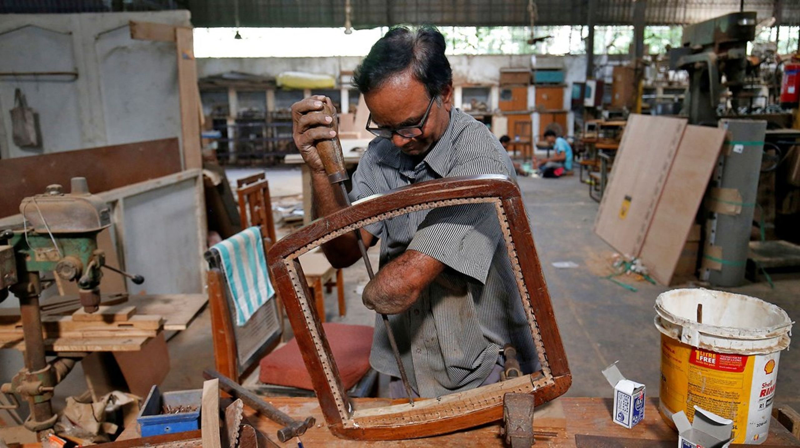 En mand, der har mistet sin arm i en ulykke, laver en stol i et træningscenter for mennesker med handicap i Indien. Arkivfoto.