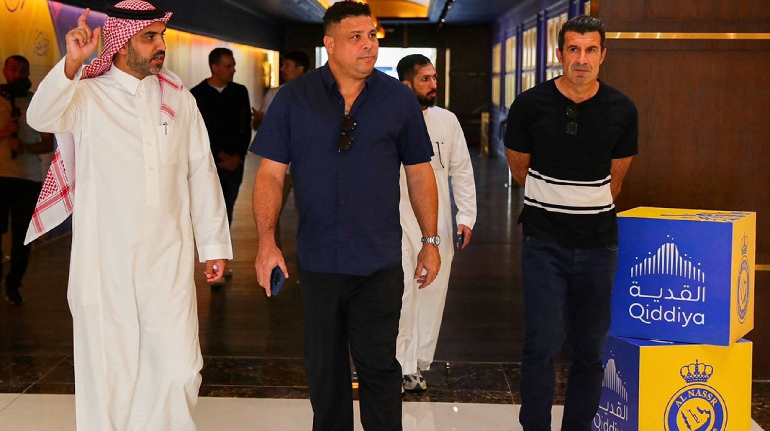 Play the Game har kortlagt Saudi-Arabiens vidtforgrenede økonomiske interesser i international sport. Her ses de pensionerede fodboldstjerner Luis Figo og brasilianske Ronaldo på besøg i styret under stort presseopbud.
