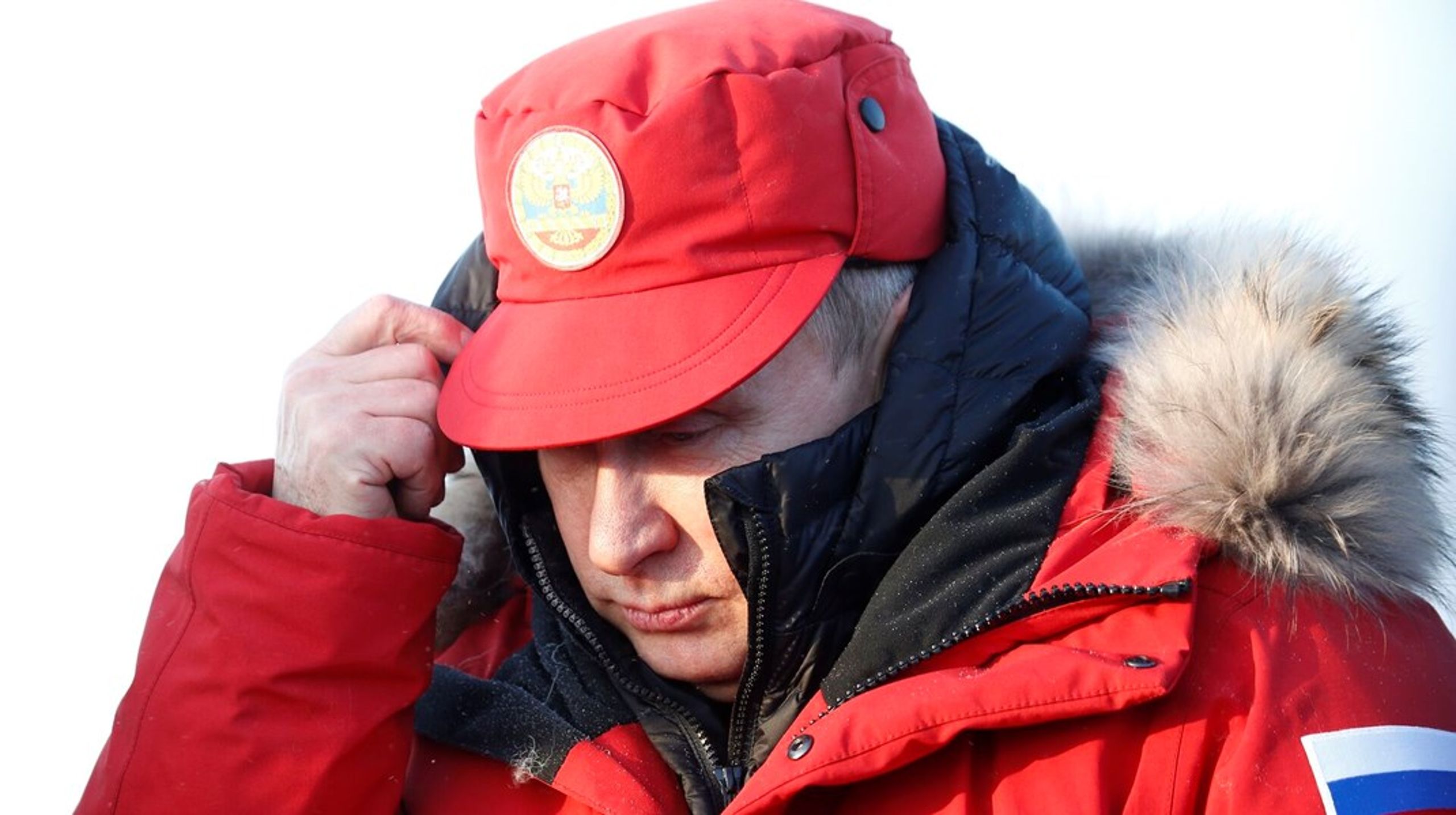Den russiske præsident Vladimir Putin forsøger at holde varmen under et besøg på militærbasen Nagurskoya på Alaxandra Ø i Franz Josef Land i 2017.