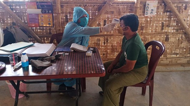 En mand får målt sin temperatur i verdens største flygtningelejr, Cox's Bazar. Care Danmark har flyttet 8,2 mio. kr. fra eksisterende projekter til covid-19-forebyggelse i bl.a. Cox's Bazar. 